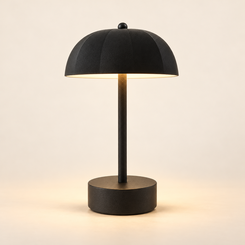 Milo rechargeable mushroom table lamp in black, softly illuminated against a warm ivory background.